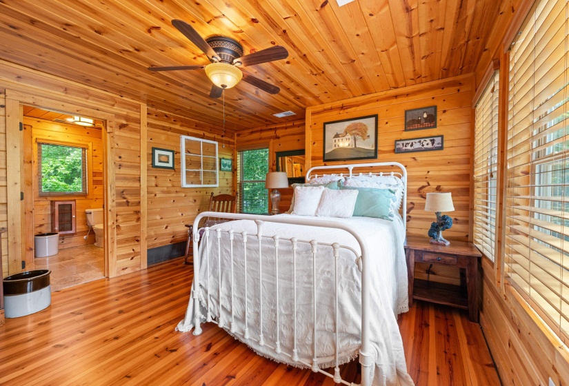 Wood-paneled room featuring a ceiling fan with integrated lighting, wood-finish flooring, and a large window with horizontal blinds