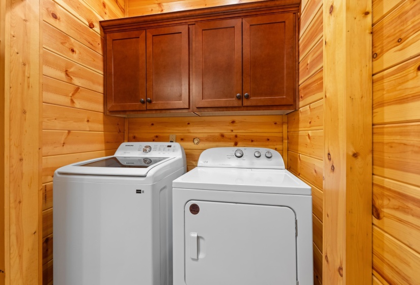 Utility space featuring wood-paneled walls and a wood-finish column