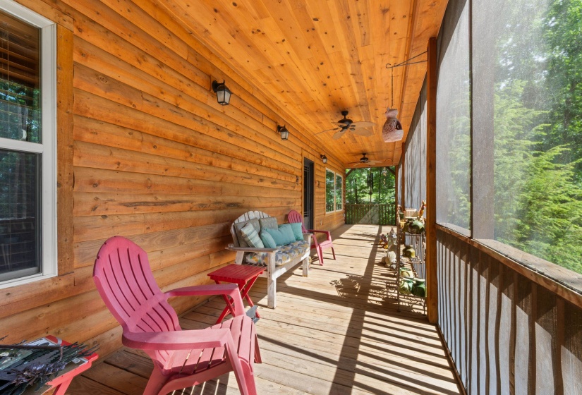 Expansive screened porch featuring wood-finish flooring, a planked wood ceiling, and exposed wood siding