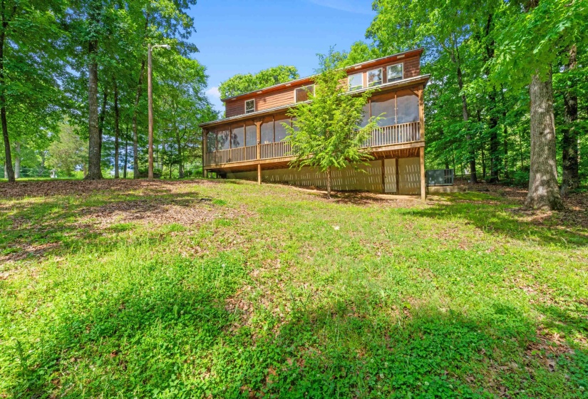 Two-story residence featuring a screened-in porch with wood railing and slatted wood privacy screening
