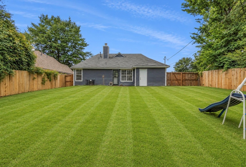 Expansive rear yard featuring a large grass lawn
