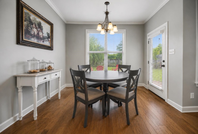 Dining area featuring wood-finish flooring, a bright window, and a glass-paneled door