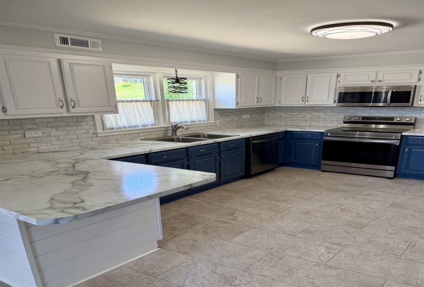 Modern kitchen featuring a dual-tone cabinetry design, white upper cabinets, and deep blue lower cabinets