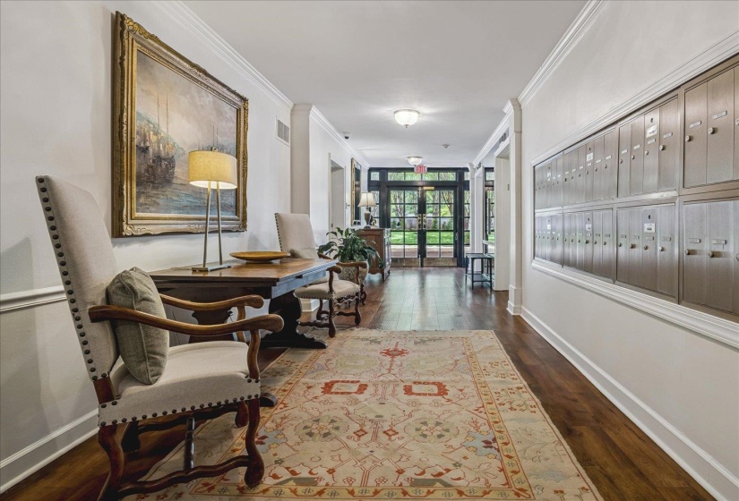 Elegant entryway featuring dark wood-finish flooring, white crown molding, and a decorative area rug
