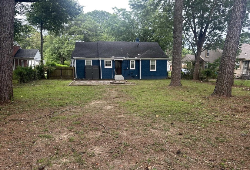 Rear exterior featuring a blue facade, white window trim, and a dark shingled roof