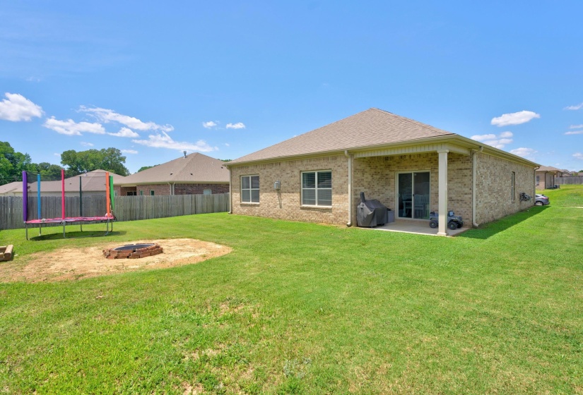 Expansive green lawn featuring a dedicated fire pit area