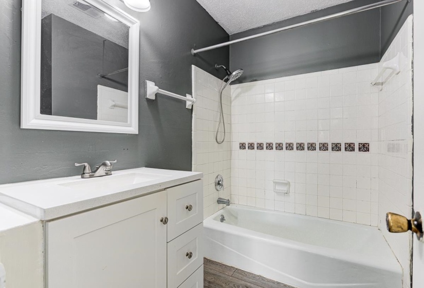Bathroom featuring a white vanity with integrated sink, chrome-finish faucet, and coordinating framed mirror