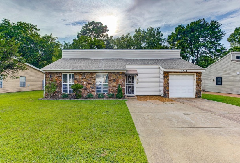 Stone and siding exterior with a single-car garage and a concrete driveway