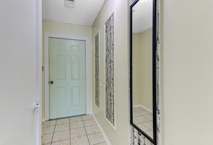 Foyer featuring light-toned tile flooring, a paneled door, and neutral wall paint