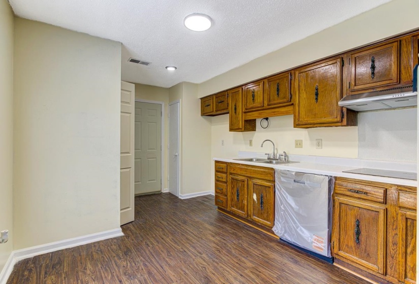 Kitchen featuring wood-finish flooring and a full suite of wood cabinetry