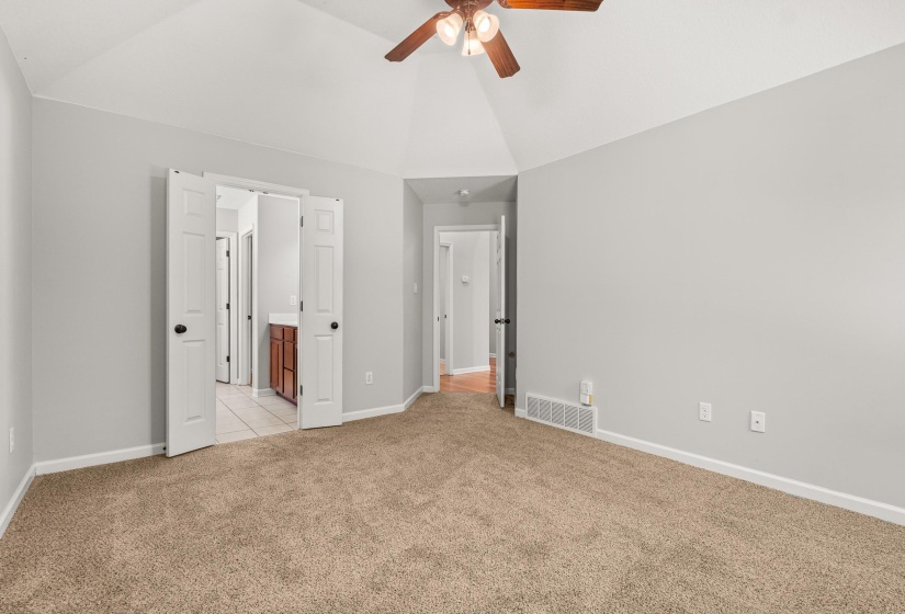 Neutral wall paint colors complement the vaulted ceilings and ceiling fan