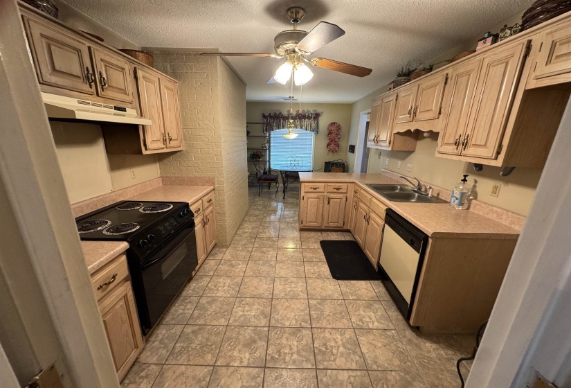 Functional kitchen featuring light-toned cabinetry, a black electric range, and a dual basin stainless steel sink