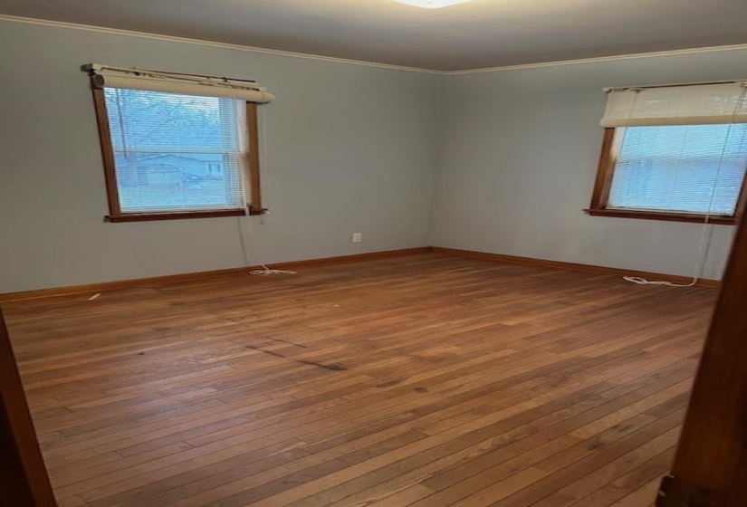 Empty room with crown molding, healthy amount of natural light, and hardwood / wood-style floors