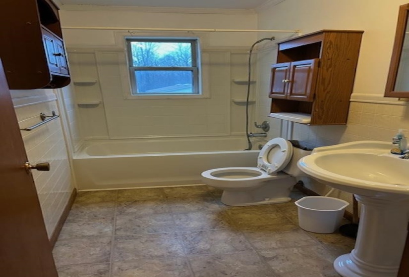 Bathroom with tile walls, tub / shower combination, and wainscoting