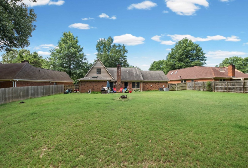 Expansive green lawn with a full wooden fence