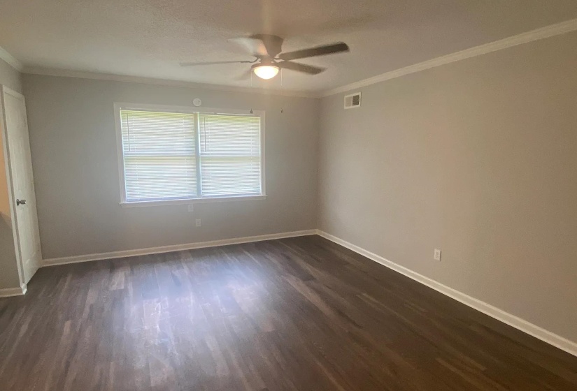 Spacious room featuring wood-finish flooring and neutral wall tones