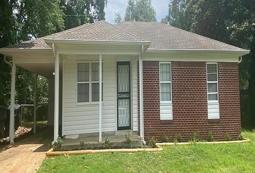 Single-story residence featuring a carport, a combination of brick and siding exterior, a front entry with a security screen door, multiple windows with grilles, and a shingled roof