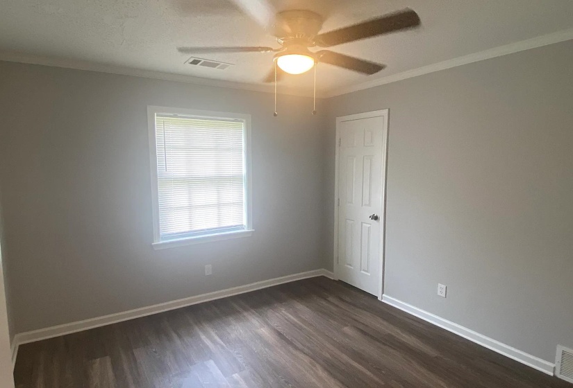 Room featuring wood-finish flooring, light gray wall paint, and white trim