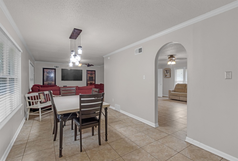 Dining area with tile flooring and a multi-bulb linear chandelier