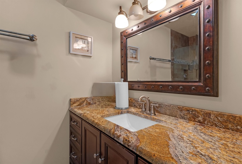 Bathroom vanity with a richly veined countertop, undermount sink, and brushed nickel faucet