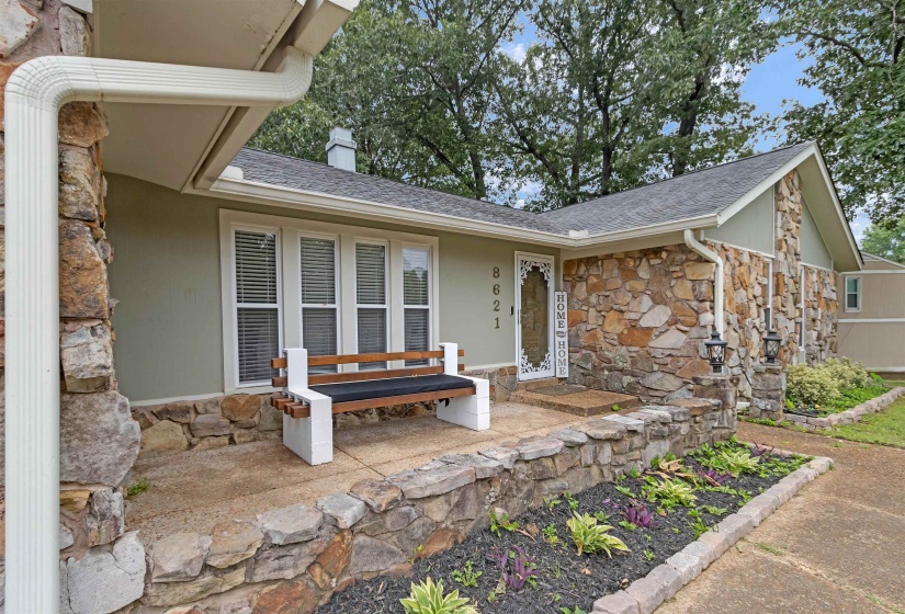 Stone veneer facade with light green siding and a dark gray shingle roof