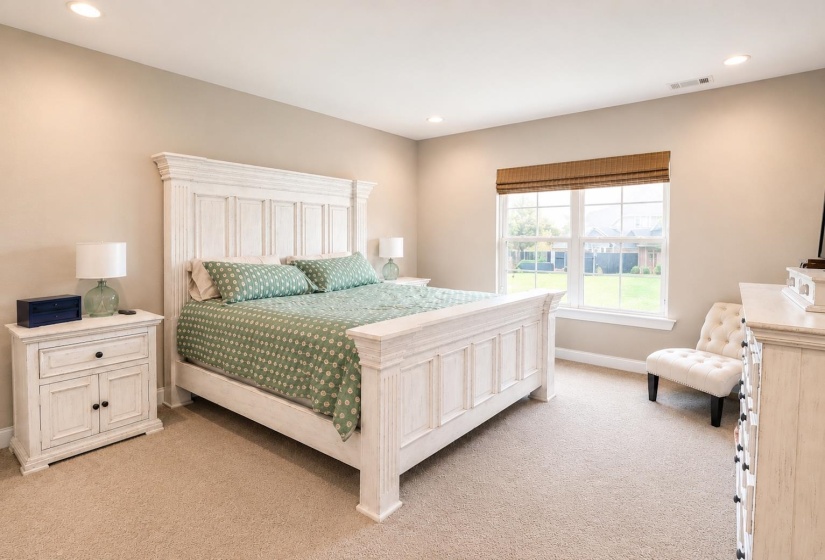 Carpeted bedroom featuring recessed lighting and a double-pane window with a woven shade
