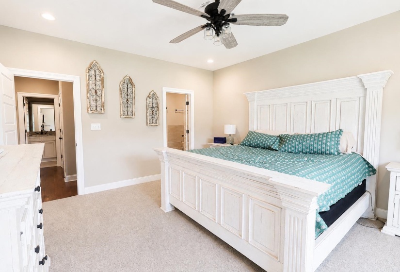 Spacious bedroom featuring light-toned carpeting, a ceiling fan with integrated lighting, and recessed lighting
