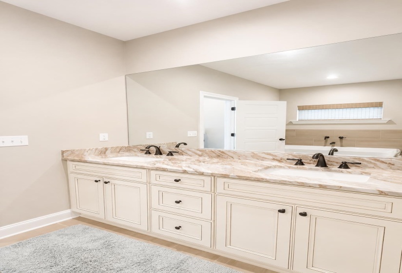 Dual vanity with integrated sinks, stone-finish countertop, and dark-toned fixtures