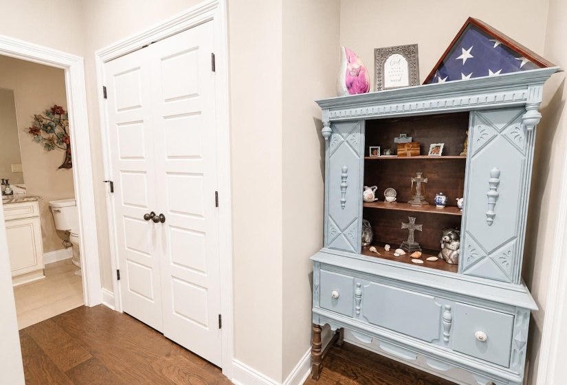 White paneled double doors with dark hardware, wood-finish flooring, and light wall paint
