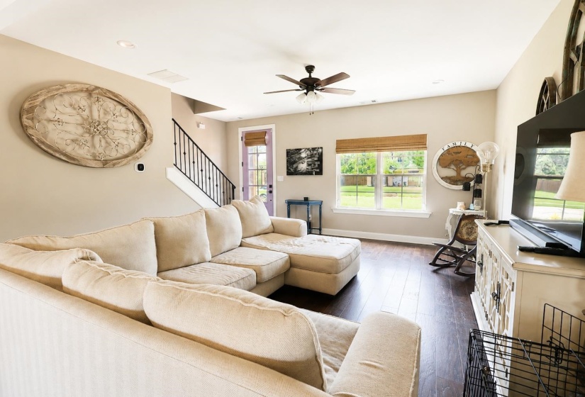 Spacious living area featuring wood-finish flooring, vaulted ceilings, and recessed lighting