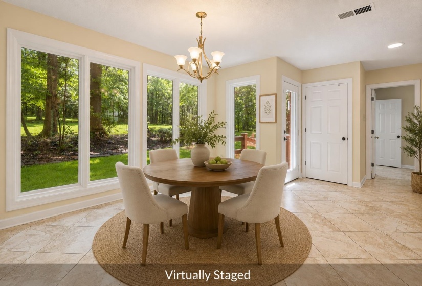 Dining area featuring a bay window with multiple panes, tile flooring, a chandelier light fixture, and light-colored walls