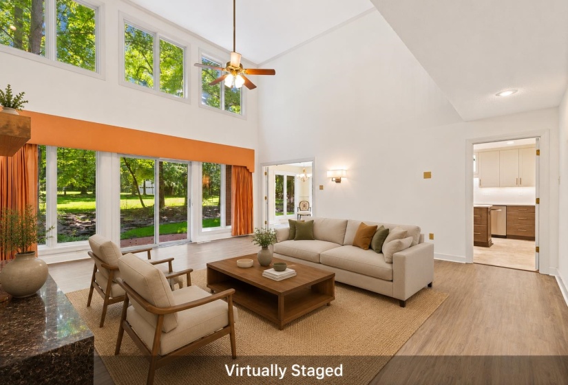 Living area featuring a soaring vaulted ceiling, wood-finish flooring, and a large sliding glass door