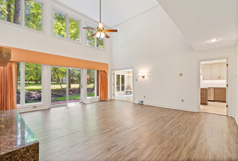 Vaulted ceiling living area featuring wood-finish flooring