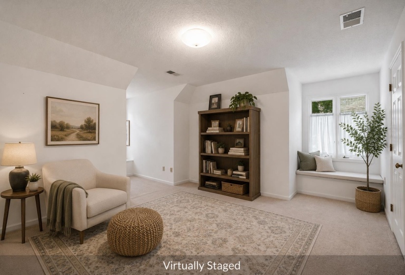 Spacious room featuring vaulted ceilings, neutral carpeting, and a built-in window seat with a multi-pane window