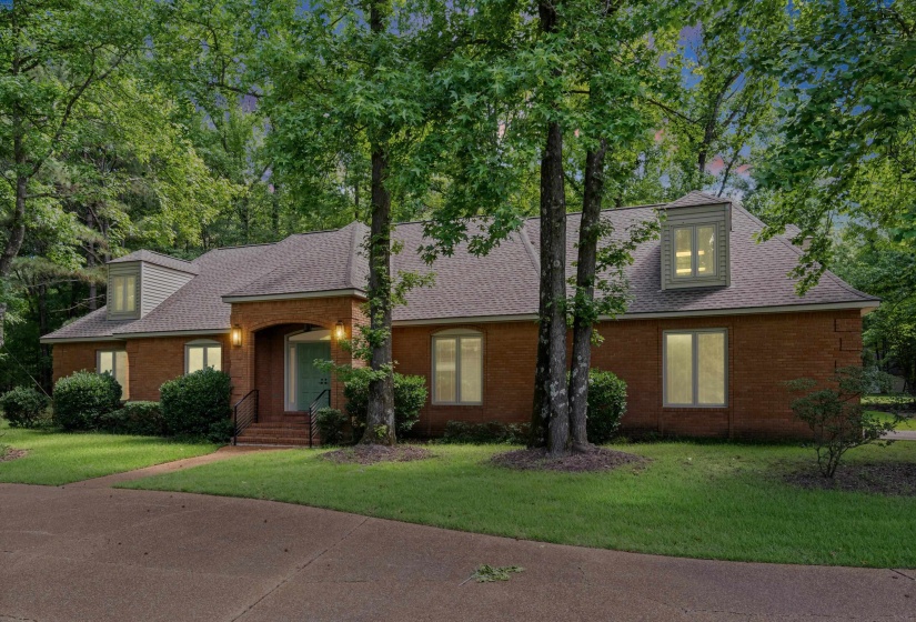 Brick exterior residence featuring multiple dormer windows and a shingle roof