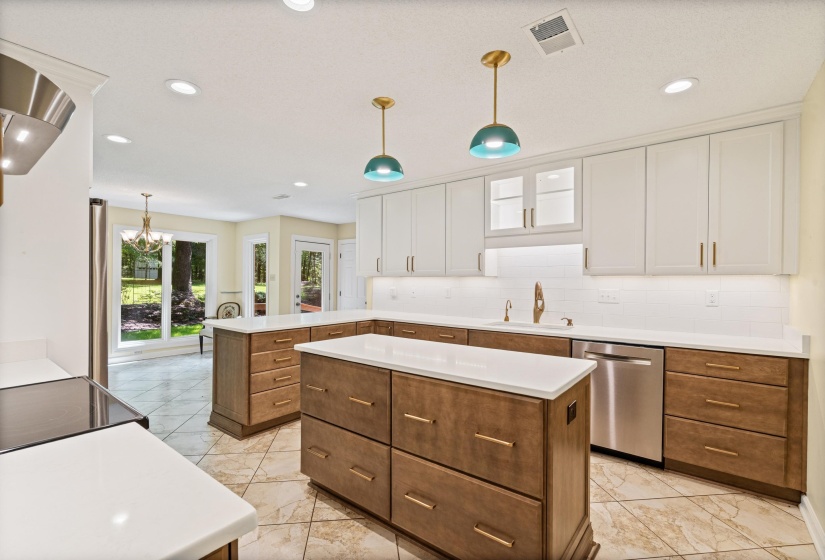 Contemporary kitchen featuring two-tone cabinetry, stainless steel appliances, white countertops, and recessed lighting