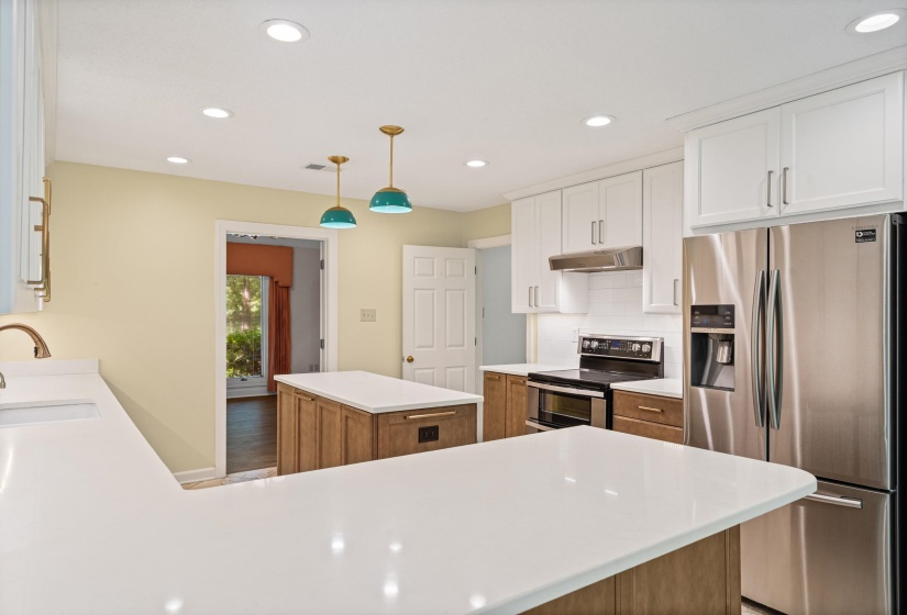 Kitchen featuring white upper cabinetry, wood-finish lower cabinetry, and white countertops