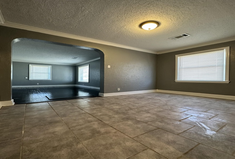 Tiled flooring throughout the foreground room, featuring a coved ceiling with a flush-mount light fixture