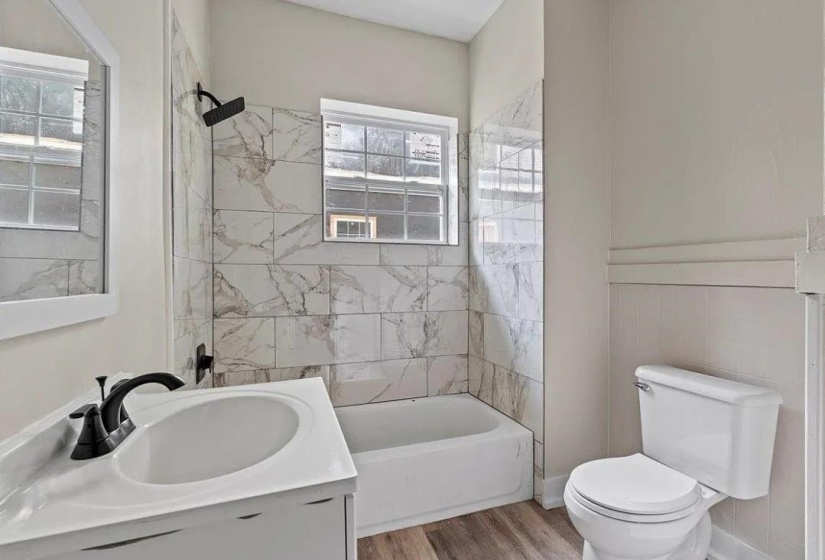 Bathroom featuring a white vanity with integrated sink, matte black faucet, and a large wall-mounted mirror