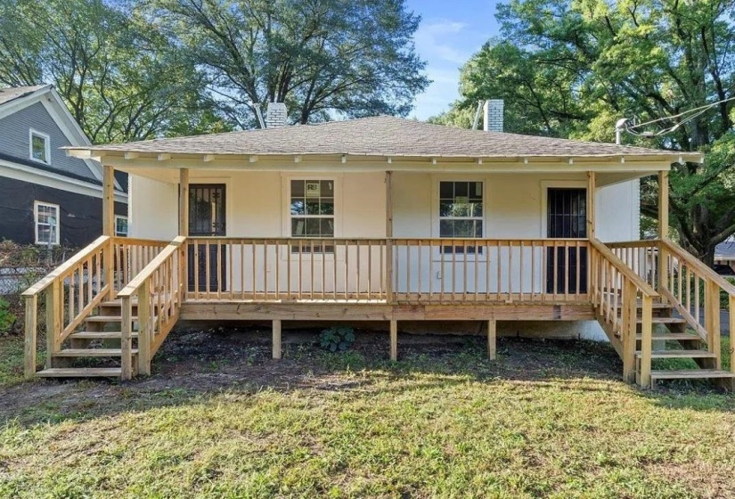 Exterior featuring a covered porch with natural wood railings, dual stair access, white facade, and a shingled roof