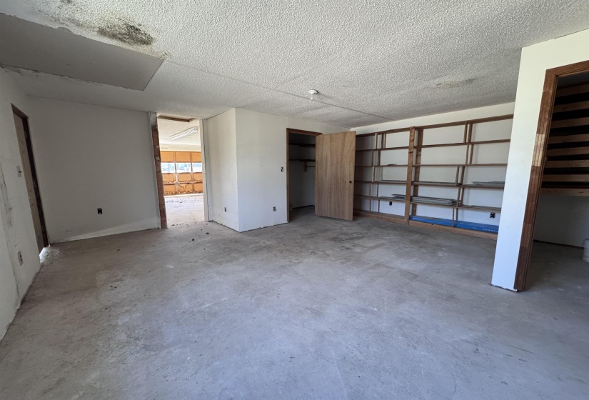 Unfurnished bedroom with concrete floors and a textured ceiling