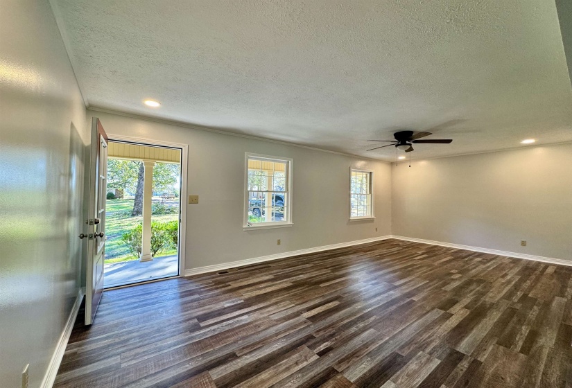 Unfurnished living room with a textured ceiling, dark wood finished floors, recessed lighting, and ceiling fan
