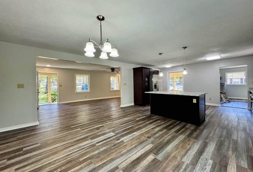 Kitchen with open floor plan, a center island, decorative light fixtures, ceiling fan, and a chandelier