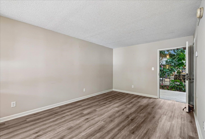 Spacious interior with neutral wall tones, wood-finish flooring, and white baseboards