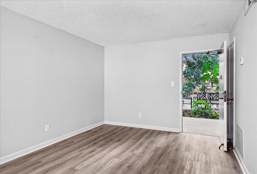 Interior room featuring wood-finish flooring, light grey walls, and white baseboards