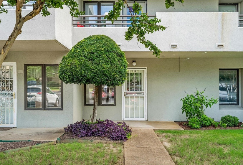 Ground-level unit entrance featuring a white security screen door and a concrete walkway
