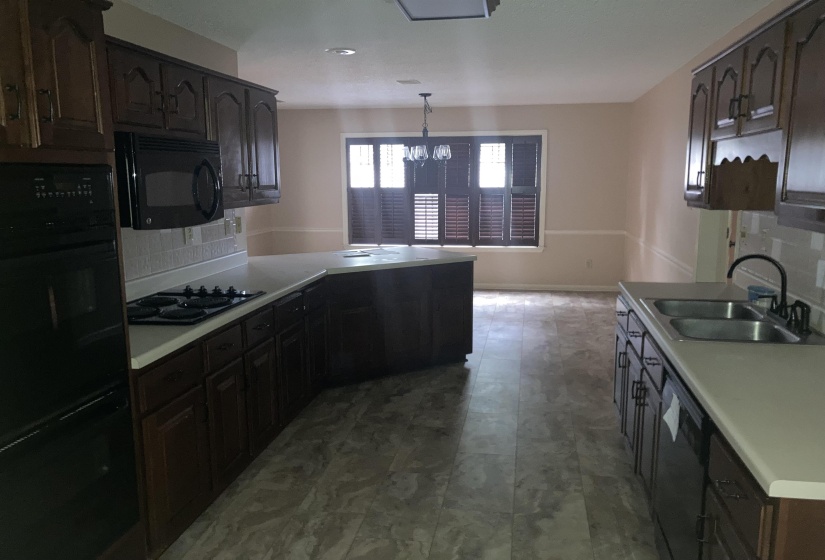 Kitchen featuring dark wood-finish cabinetry, light countertops, and a tile backsplash