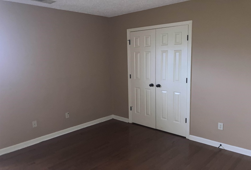 Room featuring warm neutral wall tones and wood-finish flooring