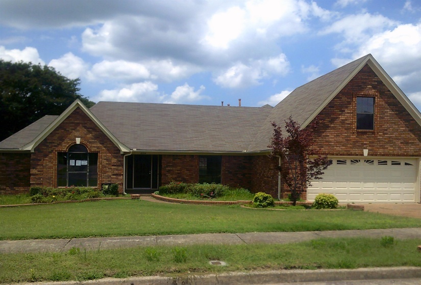 Brick exterior residence featuring a gabled roofline and attached two-car garage