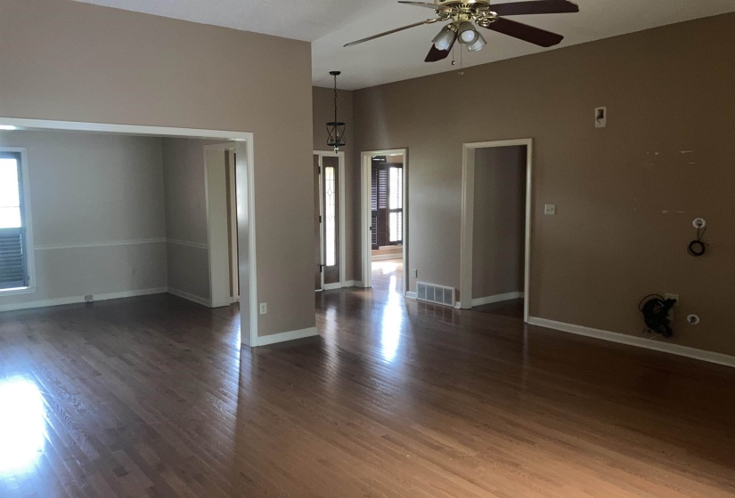 Spacious interior featuring wood-finish flooring, vaulted ceilings, and a ceiling fan with light fixture